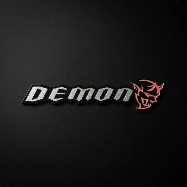 DEMON su tekstu emblema – lipdukas ant juodo paviršiaus