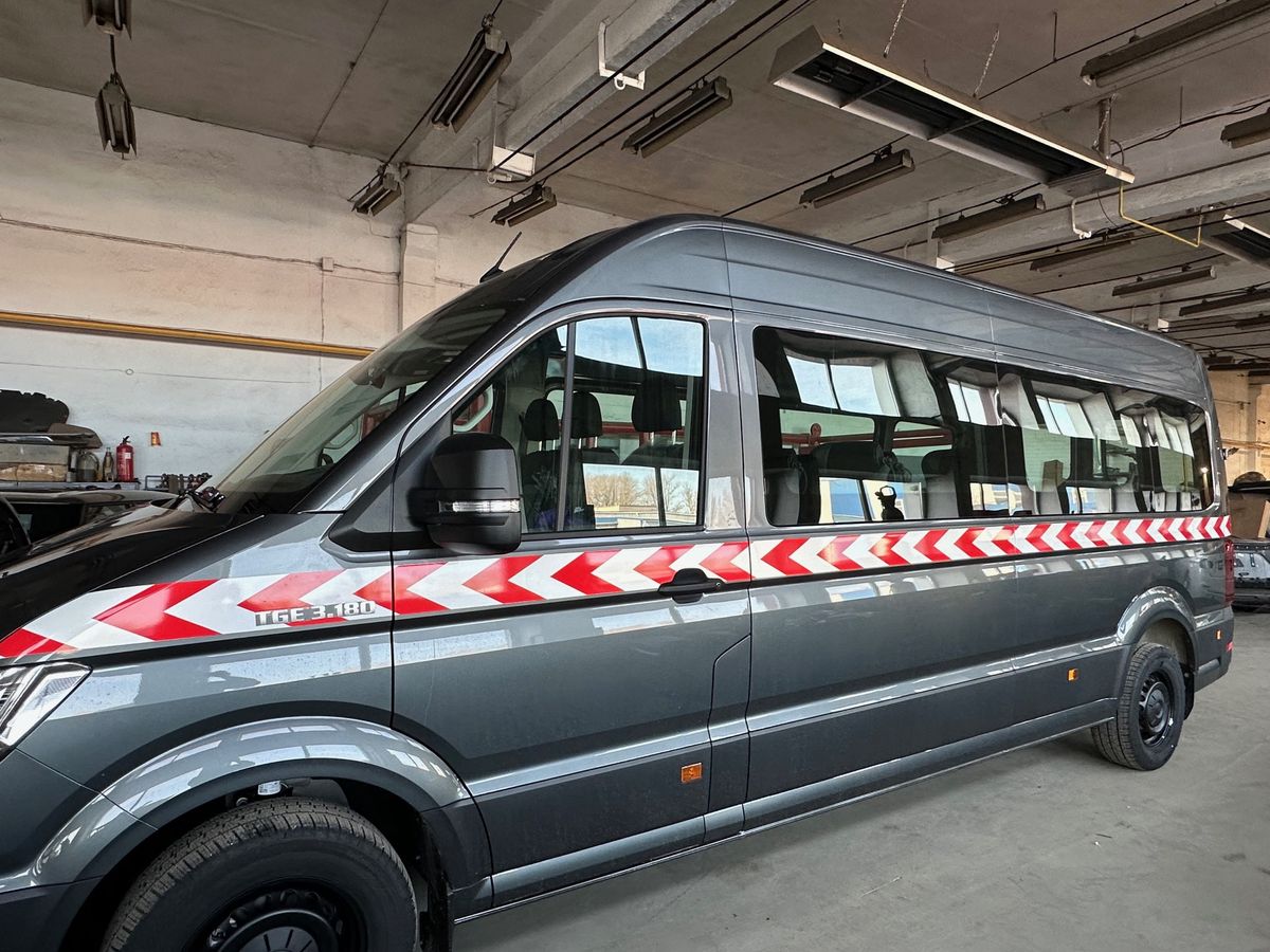 Mikroautobusas su raudonai baltais įspėjamaisiais ženklais