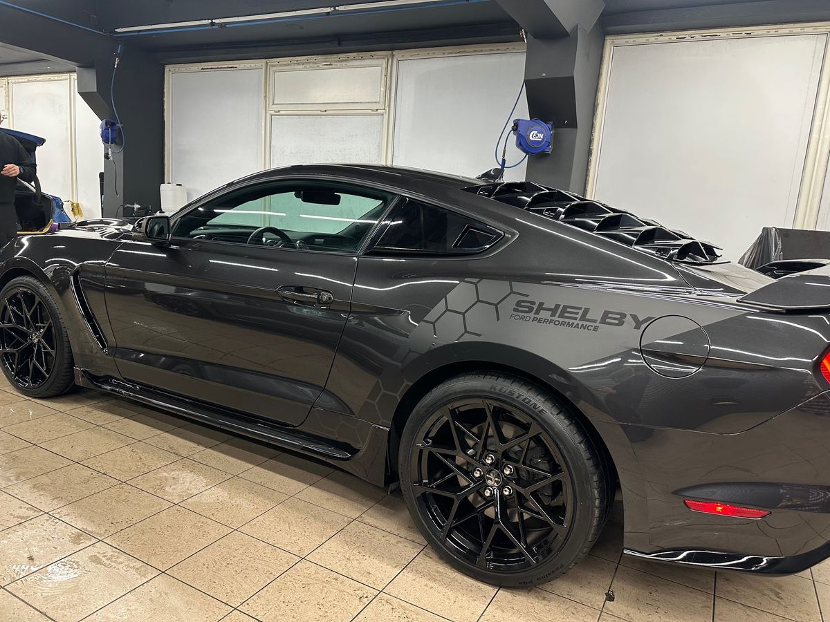 Pilkas Ford Mustang iš šono su šešiakampių grafika